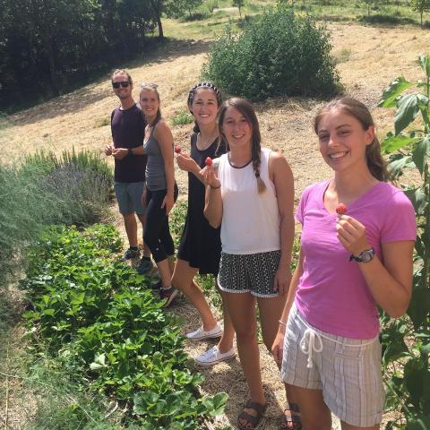 Students in a garden holding up strawberries