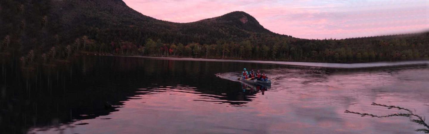 Zoology class in canoes on a lake near sunset