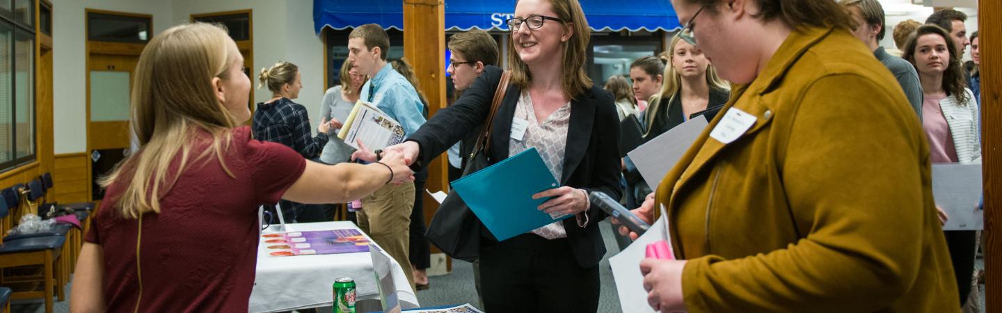 Student shaking hands at a career fair