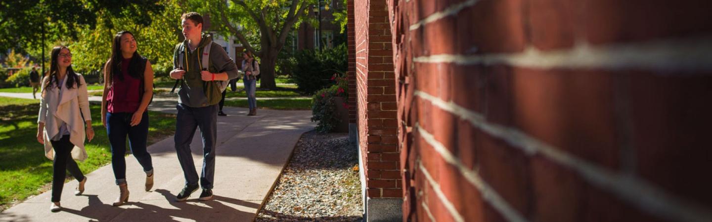 Students walking outside of building on sunny day