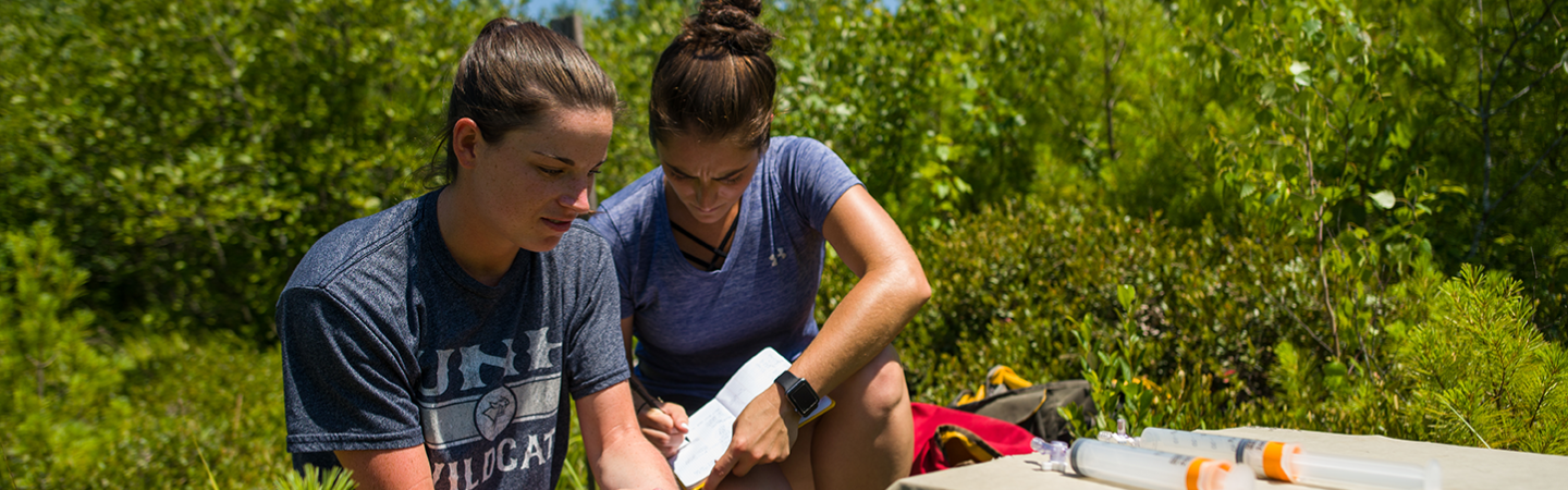 Two students researching in the field