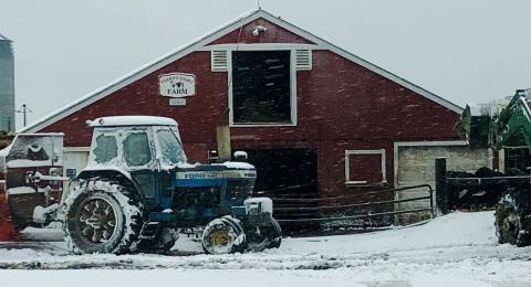 A header of a barn and truck in the snow