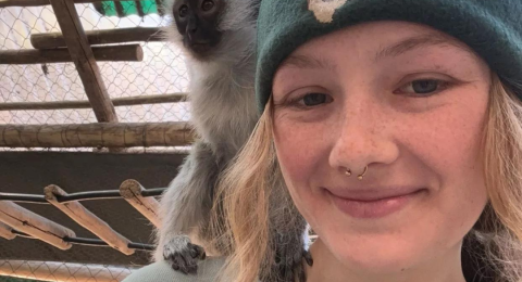 UNH student Morgan Breen with monkey on her shoulder in South Africa where she is conducting research this summer.