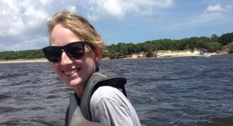 UNH graduate student Maureen Madray on a boat holding a shark