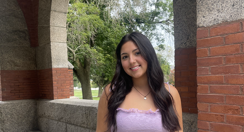 UNH student Madison Jeckell poses under Thompson Hall arch at UNH