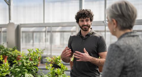 UNH President Chilton talks with research in the UNH Macfarlane Research Greenhouses