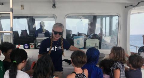 UNH marine, estuarine and freshwater biology major Marissa Cartee '21 talks to children during a whale watch