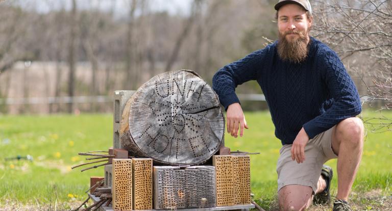 Wyatt Shell '20G poses next to the carpenter bee nest he designed.