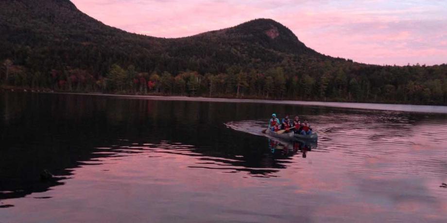 Zoology class in canoes on a lake near sunset