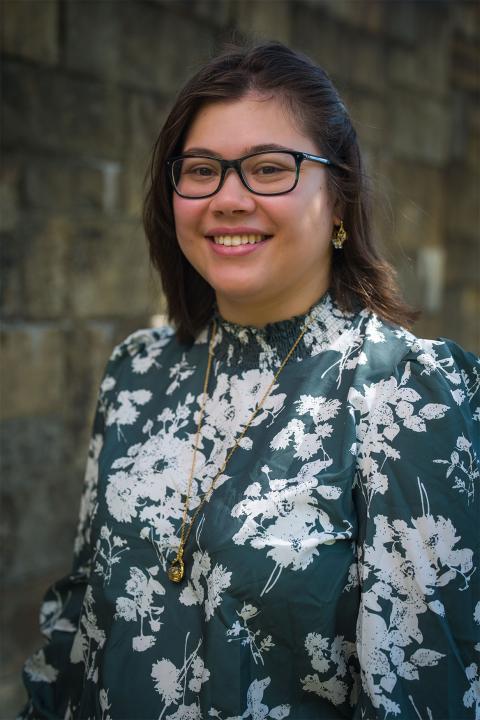 Master of Science in Agricultural Sciences student Isabella Borrero. Isabella has light-brown skin and short dark-brown hair that's cropped at her shoulders. She wears black-rimmed glasses and wears a green and white floral print top.