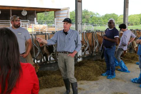 UNH Organic Dairy Research Farm manager Jason Scruton speaks to a crowd of people.