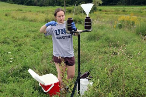 A CEPS student gathers rainwater collected for a PFAS measurement study.