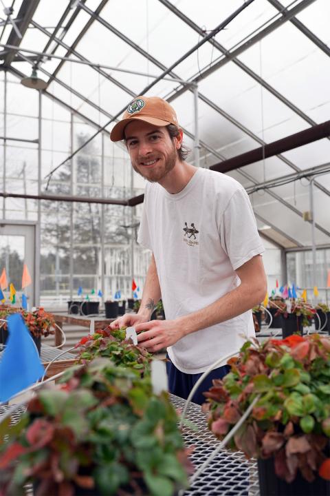 UNH assistant greenhouse manager Tim Fischer looks into the camera smiling.