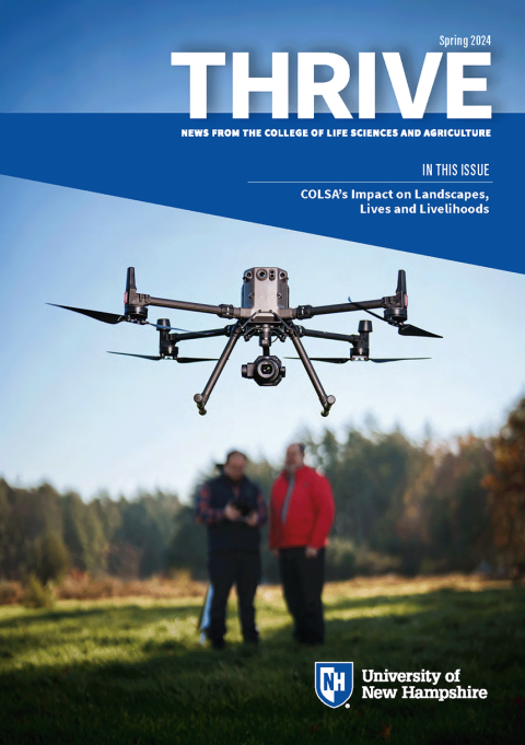 The Thrive Spring 2024 cover showing a drone hovering the foreground and two people standing in the background in a field and holding a controller for the drone.