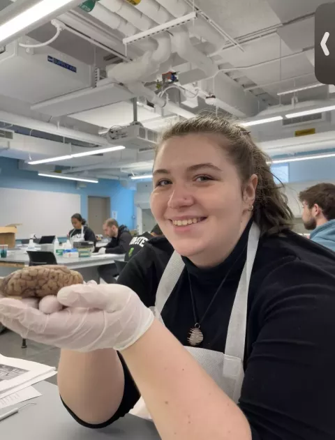 UNH neuroscience and behavior major Amanda Wittemann holding a brain during class