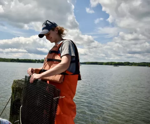 UNH graduate student Kelsey Meyer-Rust handles crab trap on Great Bay