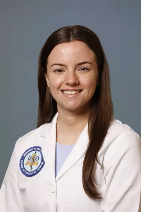 UNH alumna and medical school student Samantha Ansart in her white coat 