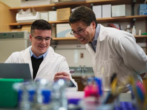 Professor Mao Chen and student examine samples in the lab