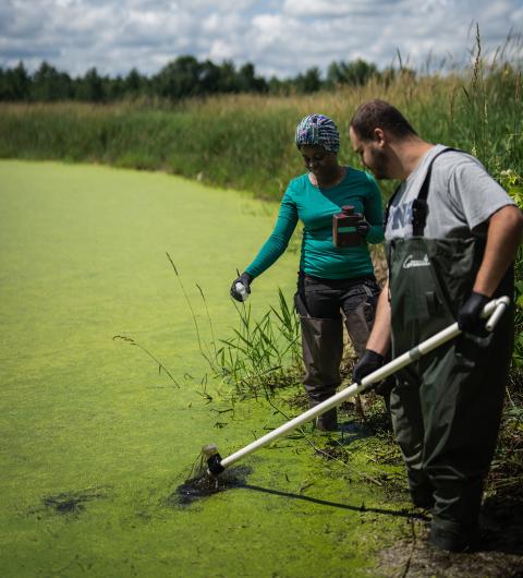 Two UNH graduate students taking water samples