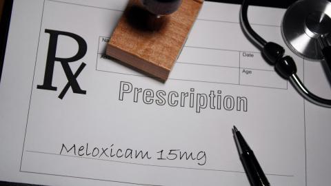 A photo of a prescription pad with the words "Prescription Meloxicam 15 mg" written on it.