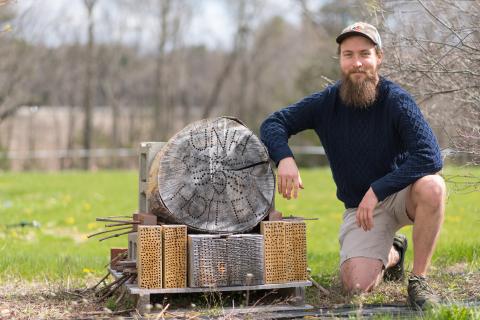 Wyatt Shell '20G poses next to the carpenter bee nest he designed.